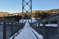 Besneeuwde brug over de rivier