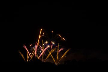 Vuurwerk in oranje en geel explodeert in de nacht op fantastisch feest van adventure-photos