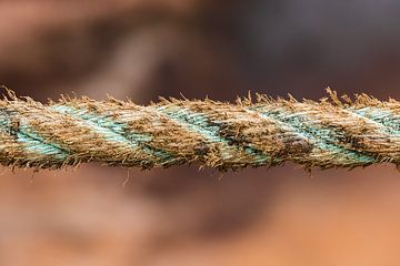 Weathered brown blue rope from a ship in Greenland by Martijn Smeets