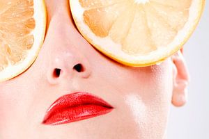 SF00989776 Vrouwengezicht met ogen bedekt met sinaasappelschijven van BeeldigBeeld Food & Lifestyle