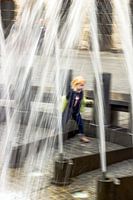 Kleines Mädchen spielt am Brunnen