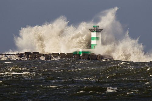 Golven van de Noordzee beuken op de vuurtoren van IJmuiden