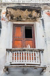In verval geraakt balkon met houten deur