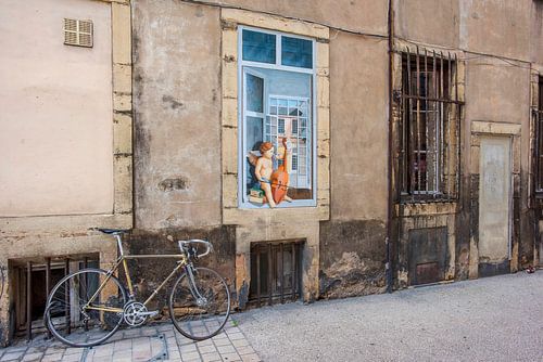 Un vélo et un ange contre une vieille façade française sur Blond Beeld