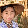 Portrait d'une fille avec un tanaka et un chapeau de paille dans la campagne du Myanmar. sur My Footprints