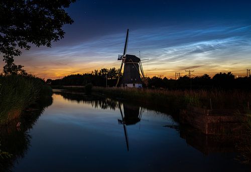 Nuages nocturnes lumineux au-dessus d'un moulin à vent dans le polder sur Theo van Veenendaal