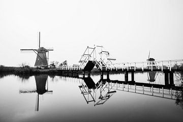 Windmolens in Kinderdijk met brug in zwart-wit van Jeroen Stel
