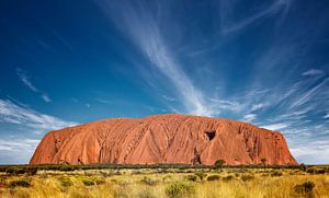 Uluru (Ayer's Rock) bij zonsopgang onder mooie pluizige wolken