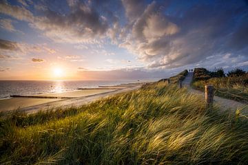 Sunset on the coast of Zeeland, dune path with two walkers by Henno Drop