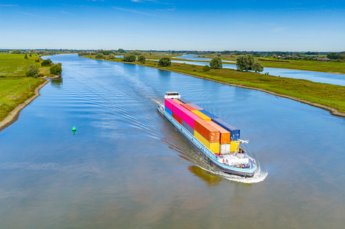 Container ship on a river seen from above