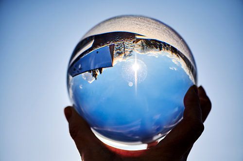 View through a crystal ball onto a winter landscape.