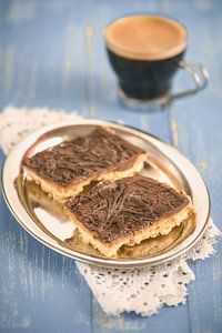 Huisgemaakte chocoladekaramel fracties liggen in een metalen kom op een blauwe houten tafel van Edith Albuschat