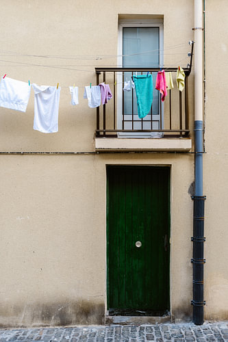 Bunte Wäscheleine über einer grünen Tür, Spanien