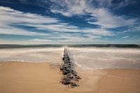 Buhne, strand en wolken