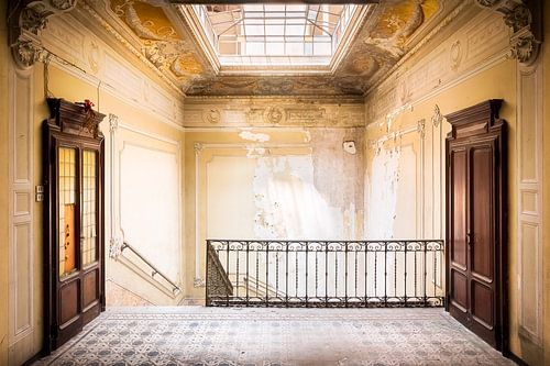 Cage d'escalier abandonné avec des portes en bois.