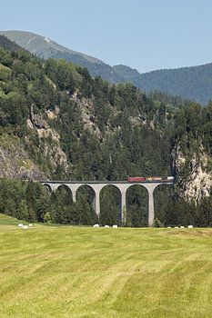 Red train across bridge in Switzerland