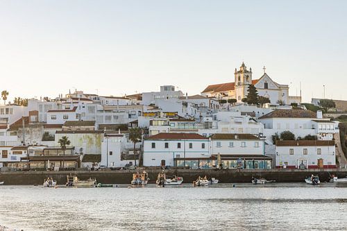 Zandstrand in de ochtend met uitzicht op het historische centrum van Ferragudo, Portimão, Algarve, Portugal