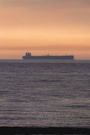 Boat with sunset Scheveningen by Anne Zwagers