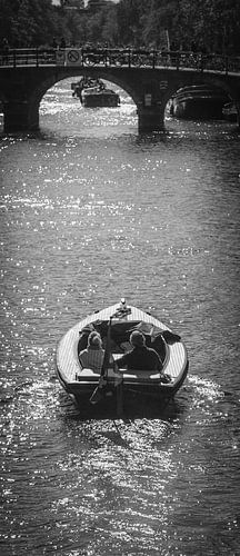 A couple in a boat sailing in Amsterdam's canals by Bart van Lier