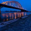 Pont sur la rivière Waal pour le Carême de Nimègue à l'aube avec un ciel bleu foncé et des lumières  sur Leoniek van der Vliet
