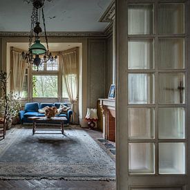 Wohnzimmer mit blauem Sofa und Klavier in einem verlassenen Haus von Inge van den Brande