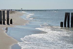 Strand mit Brandung und Pfählen im Meer