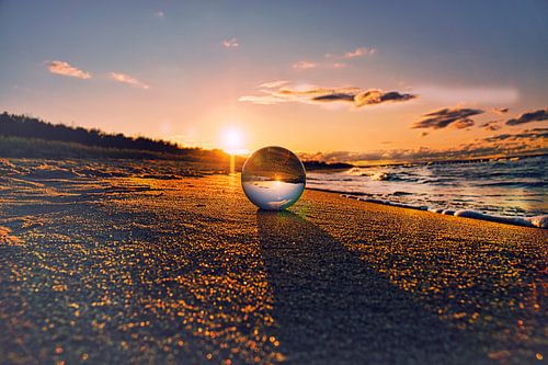 Glazen bol op het strand van Zingst bij zonsondergang
