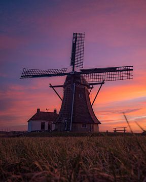 Niederländische Windmühle bei farbenfrohem Sonnenuntergang von Ewold Kooistra