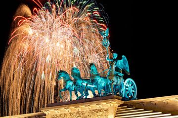 Silvesterfeier am Brandenburger Tor in Berlin mit der Quadriga im Vorgergrund und einem Feuerwerk dahinter am Himmel von Stefan Dinse