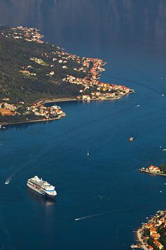 Ein schönes Kreuzfahrtschiff in der blauen Meeresbucht weit unten. Warme Töne von Fotos, die im Stil von Michael Semenov