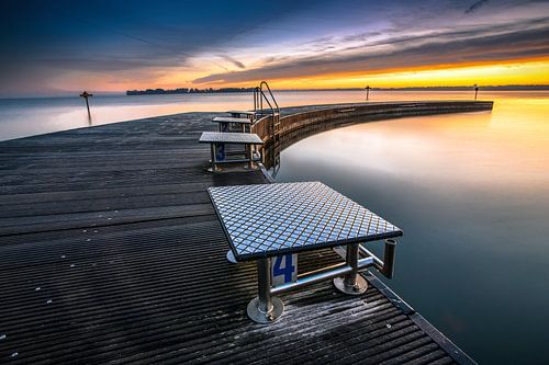 Sunset above outdoor swimming pool at the lake
