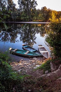 drie houten bootjes liggen in het water van de Dordogne