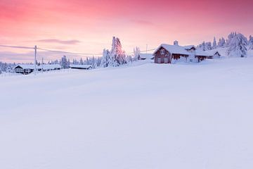 Ondegesneeuwde blokhutten in Noorwegen tijdens zonsondergang van Rob Kints