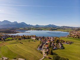 Aerial panorama of Hopfensee with Alps and blue sky in the background by Hans-Heinrich Runge