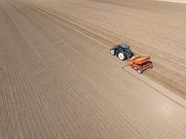 Tractor planting seed potatoes in a field during springtime by Sjoerd van der Wal Photography