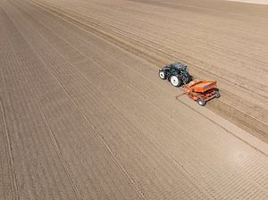 Traktor beim Pflanzen von Pflanzkartoffeln auf einem Feld im Frühling