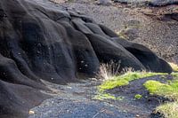 Black, cooled lava, the limit of an eruption