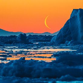 Rising moon above ice floe at orange sundown