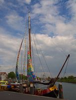 Zeilboot met kleurrijke zeilen in de haven van Zierikzee