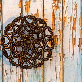 Vintage metal circle with hearts on wood by Lisette Rijkers