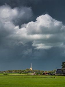 Der Kirchturm von Tzum im Sonnenlicht mit einem bedrohlichen Himmel