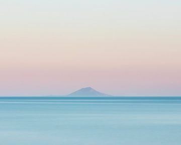 Island silhouette on horizon at sunset by Patrik Lovrin