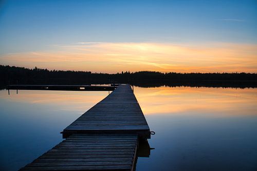 Loopbrug, naar de zonsopgang, reikend in een Zweeds meer