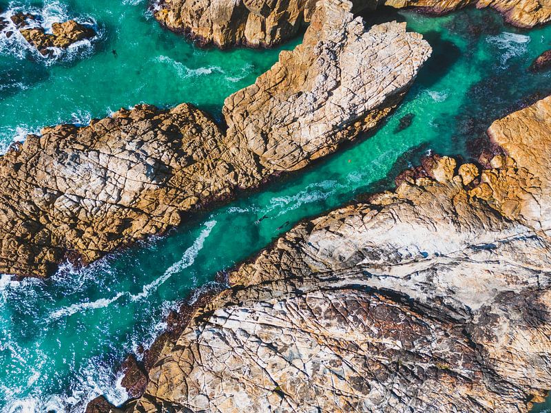 Aerial photography of two divers spearfishing among the cliffs. by Ken Tempelers