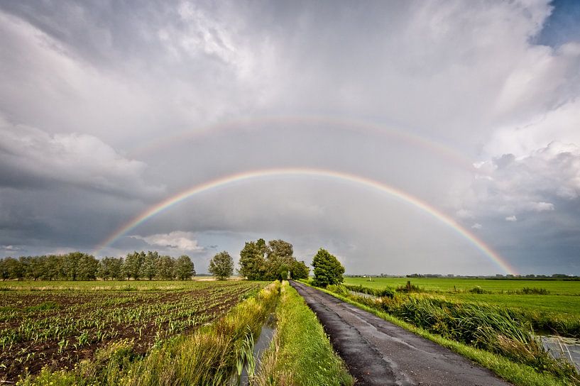 Regenboog over de polder. van John Verbruggen