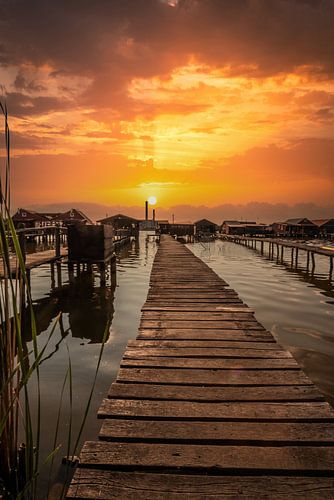 Zonsondergang over een houten steiger in het meer