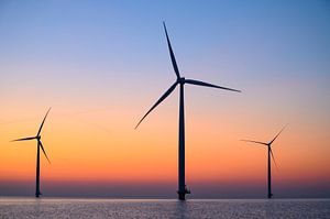 Windturbinen in einem Offshore-Windpark bei Sonnenuntergang