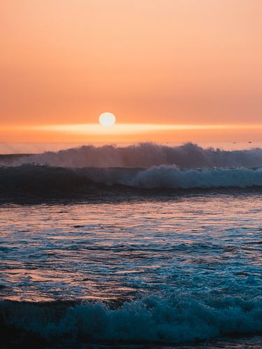 Mistige zonsondergang met golven