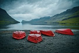Rote Boote an einem einsamen schwarzen Strand auf den Färöer Inseln von Shottrotter