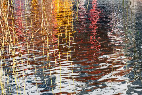 Rood-gele reflectie in Amsterdamse gracht met wilgentakken